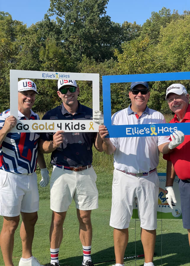 Golfers holding Ellie’s Hats and Go Gold 4 Kids photo frames at the 2024 Classic